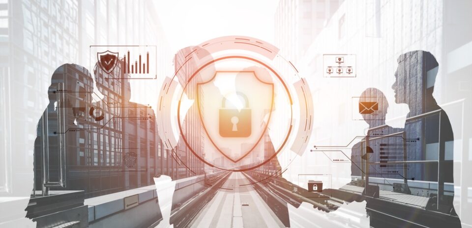 Silhouetted business partners shaking hands behind a padlock and shield